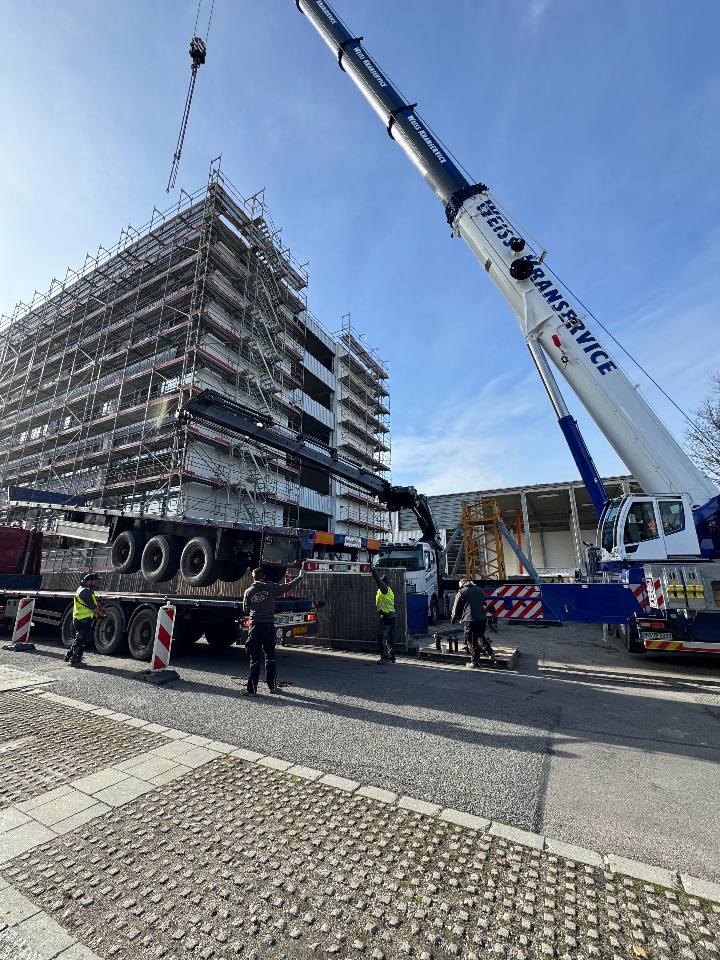 Mobilkran und Schwerlasttransport bei der Anlieferung auf der Baustelle