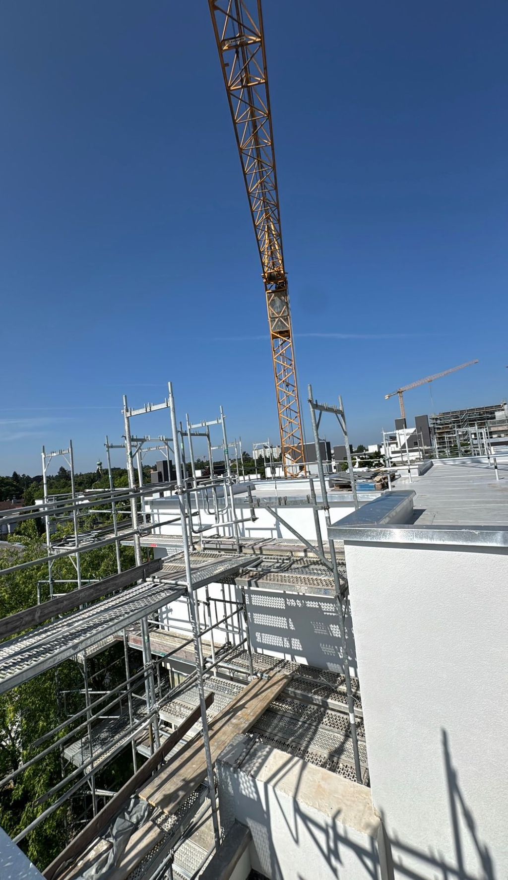 Eingerüstetes Gebäude während der Aufstockungsarbeiten mit Kran
