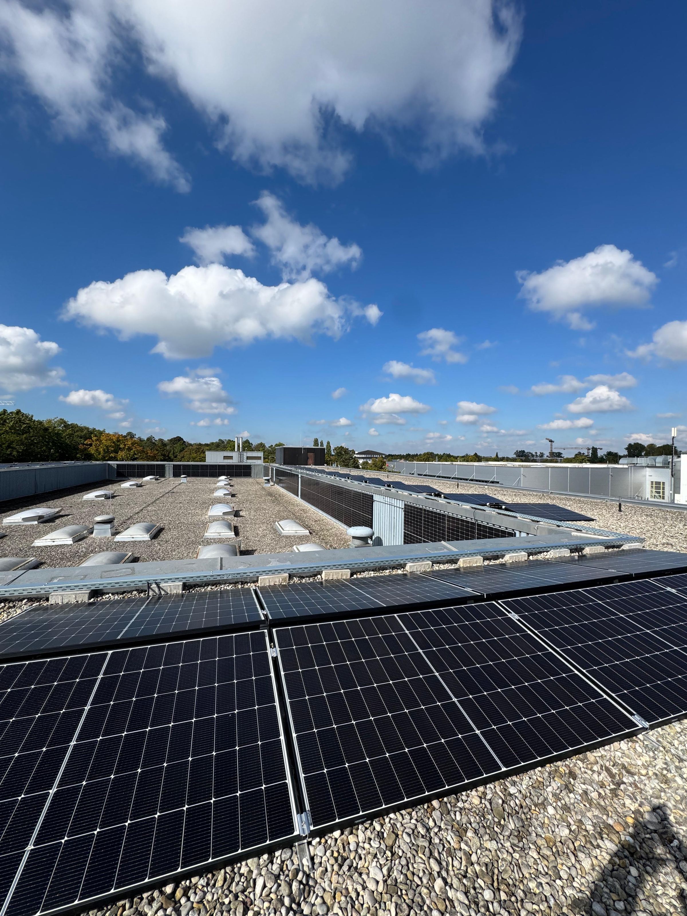 Photovoltaikanlage auf einem Flachdach in Oberschleißheim unter blauem Himmel